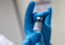 Army Spc. Angel Laureano holds a vial of the COVID-19 vaccine, Walter Reed National Military Medi...