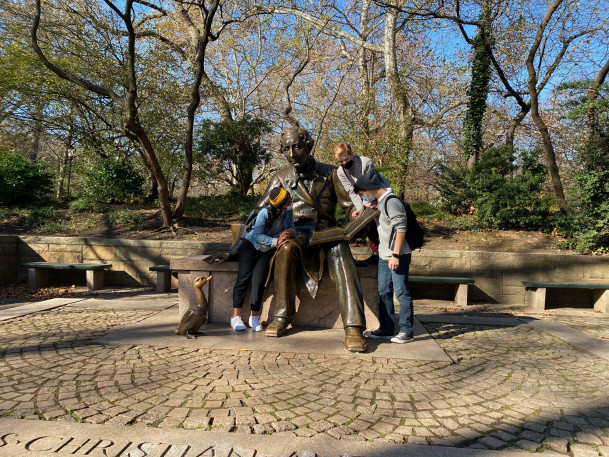 MMC students posing with the Hans Anderson statue in Central Park.